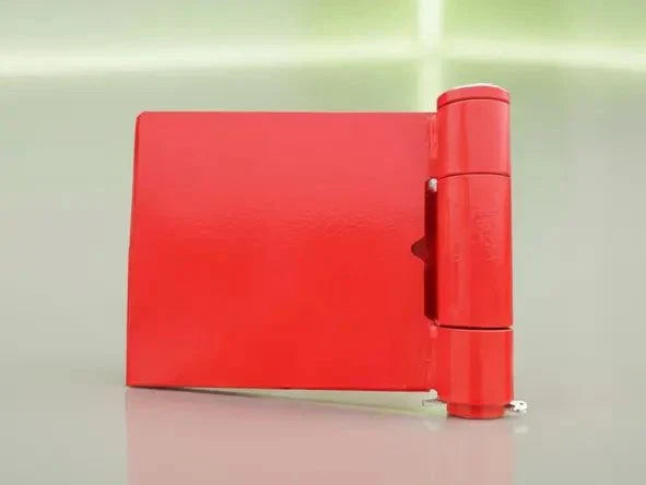 red heavy-duty weld-on door hinge with grease point on gray surface
